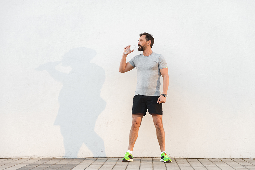 Tired sportsman drinking water