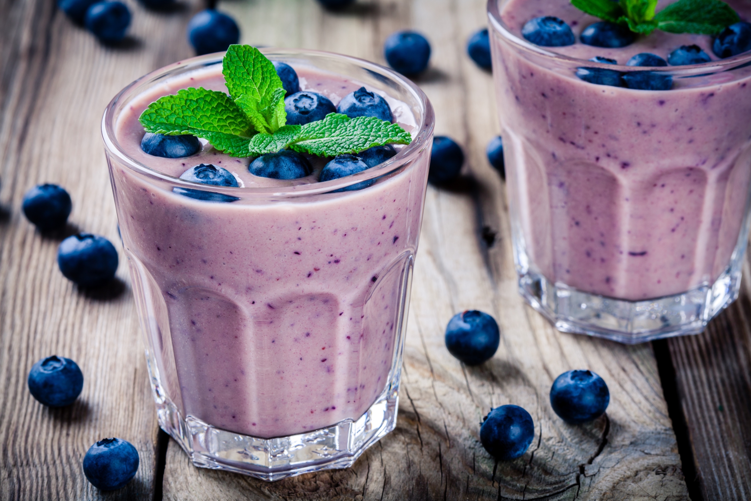 Blueberry smoothie in a glass on a rustic table