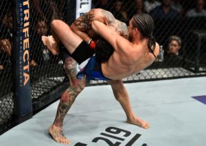 UFC fighter Brian Ortega submitting an opponent via guillotine choke.